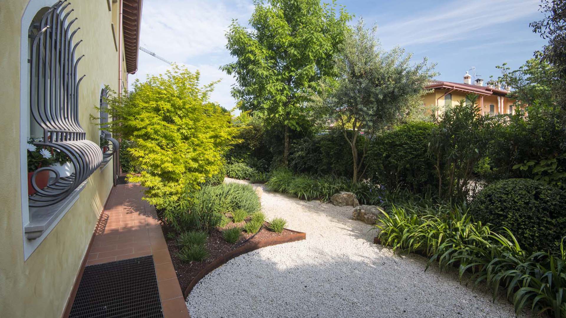 Giardino ordinato con sentiero in ghiaia e aiuole definite