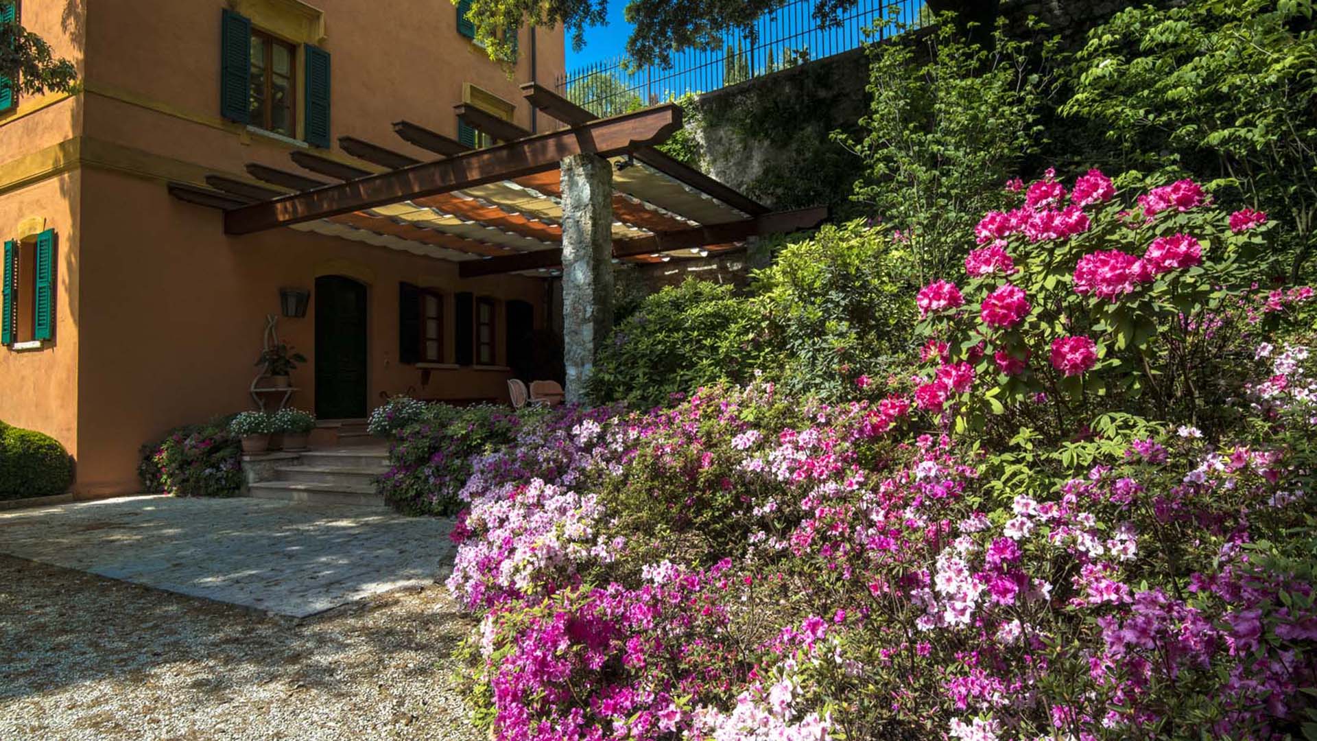 Giardino naturalistico con sottobosco ombreggiato e fioriture colorate a Gargnano