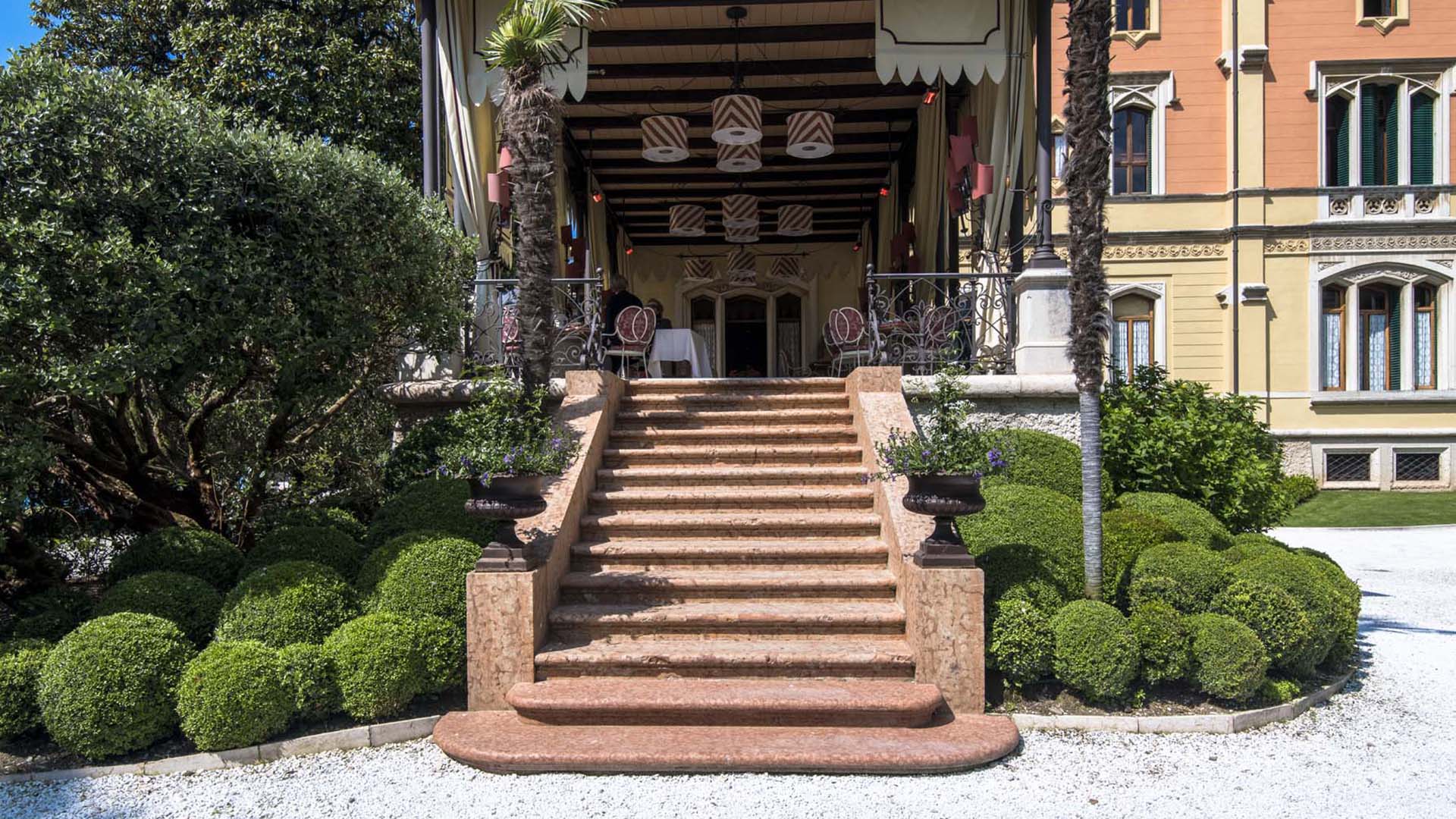 Giardino elegante con topiaria, scalinate e affaccio sul Lago di Garda