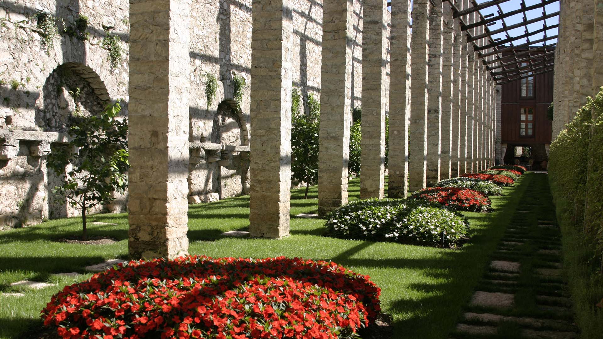 Giardino naturalistico ordinato in struttura storica con corten e colonnato